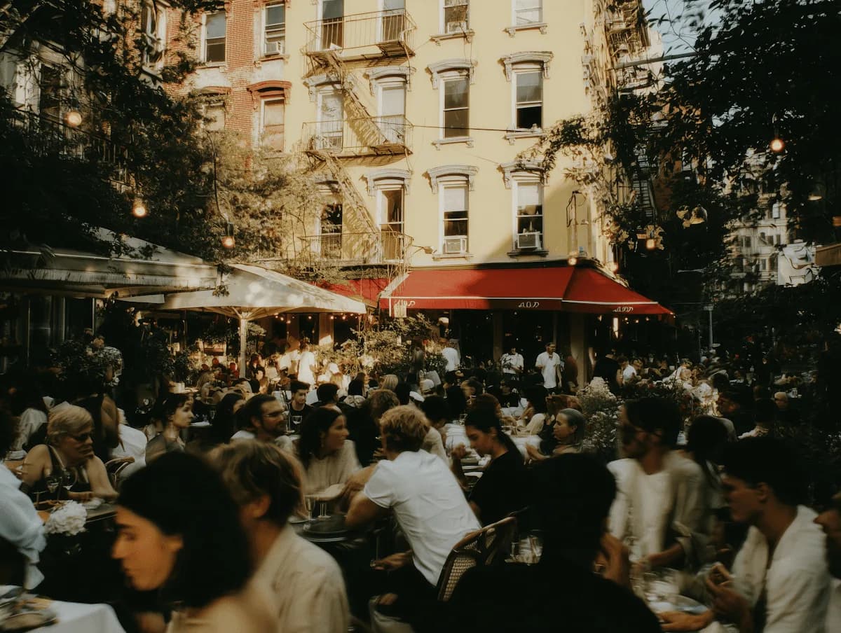La terraza de un restaurante llena de gente frente a los edificios de la cuadra
