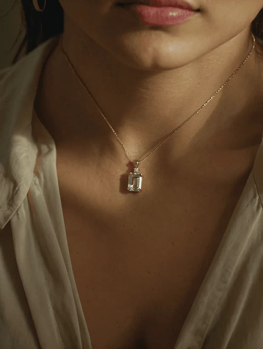 Primer plano de un colgante de oro sobre el cuello de una mujer