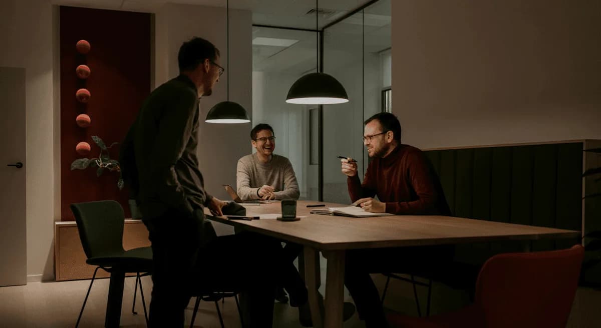Un grupo de personas reunidas alrededor de una mesa en una sala en penumbra